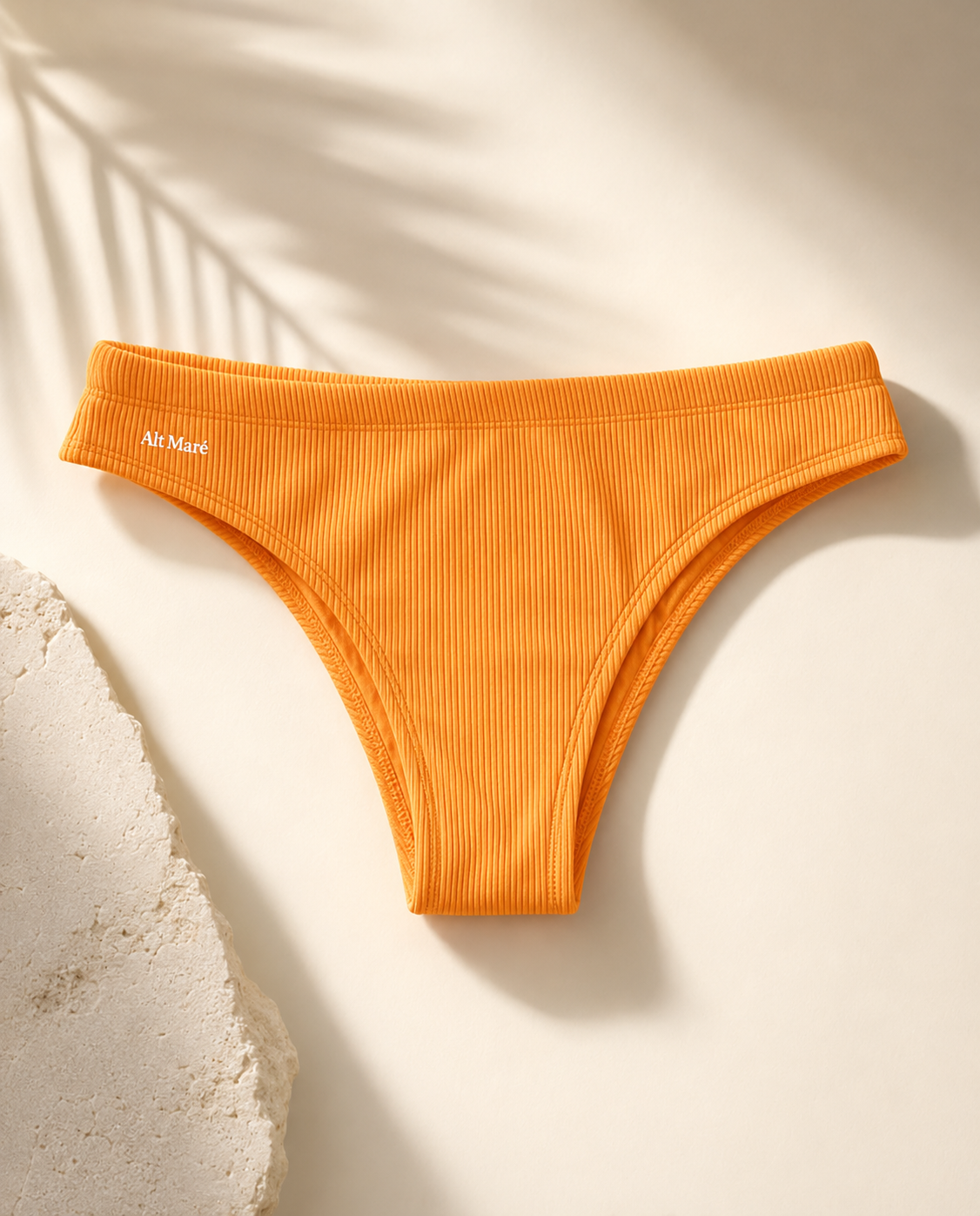 Alt Maré The Euro men's swim briefs in saffron yellow, ribbed fabric flat lay with palm shadow